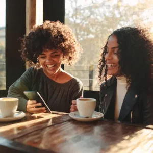 Women laughing over mobile phone